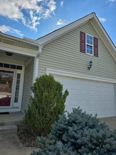 House front with siding and garage door