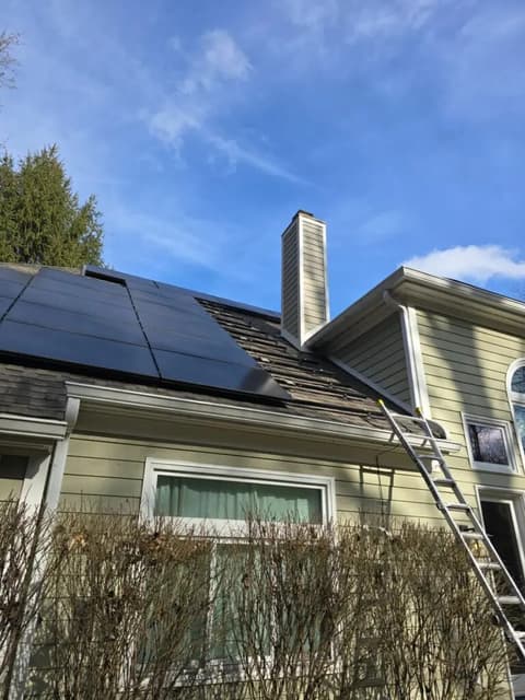 House with solar panels, chimney and ladder